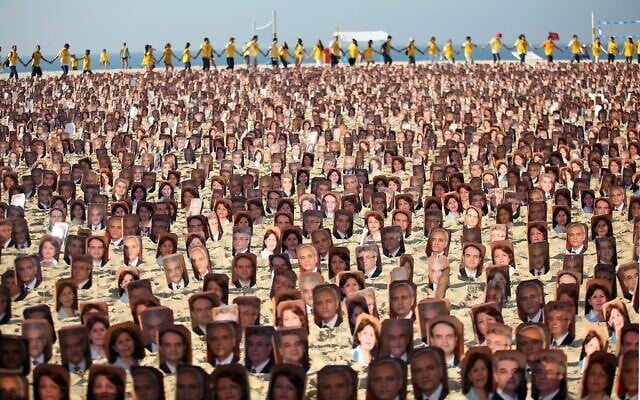 Des membres de la communauté bahaïe manifestent sur la plage de Copacabana, à Rio de Janeiro, le 19 juin 2011 pour réclamer aux autorités iraniennes la libération sept prisonniers bahaïs accusés d'espionnage au profit d'Israël et condamnés à 20 ans de prison. (Crédit : ANA CAROLINA FERNANDES / AFP)