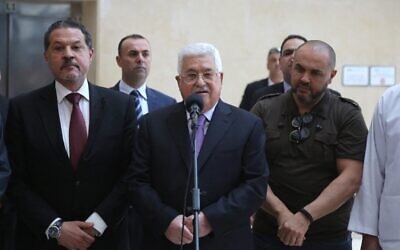 Le dirigeant de l'Autorité palestinienne, Mahmoud Abbas, entouré de ses deux fils, Yasser (à gauche) et Tarek (à droite), prenant brièvement la parole avant de quitter un hôpital près de Ramallah, en Cisjordanie, le 28 mai 2018. (Crédit : Abbas Momani/AFP)