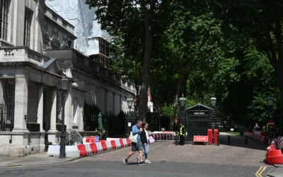 Des passants devant l'entrée fermée de la rue où se trouve l'ambassade d'Israël à Londres, le 15 juin 2025. (Crédit : Justin Tallis/AFP)