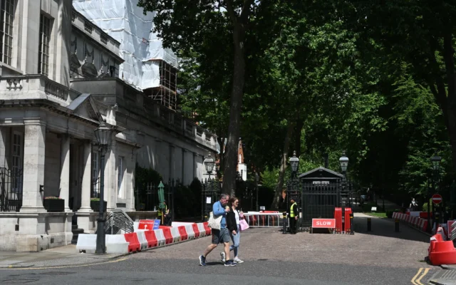 Des passants devant l'entrée fermée de la rue où se trouve l'ambassade d'Israël à Londres, le 15 juin 2025. (Crédit : Justin Tallis/AFP)