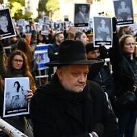 Des personnes tenant des photos des victimes lors d’une cérémonie commémorant le 31ᵉ anniversaire de l’attentat à la bombe contre l’AMIA, qui a fait 85 morts et plus de 300 blessés, à Buenos Aires, en Argentine, le 18 juillet 2025. (Crédit : Luis Robayo/AFP)