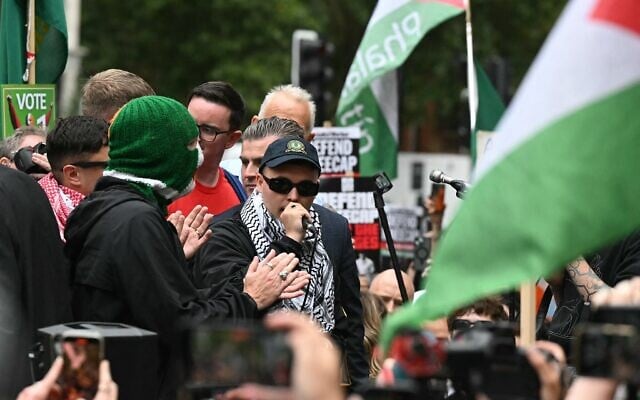 Liam O’Hanna, membre du groupe de rap irlandais Kneecap, qui se produit sous le nom de scène Mo Chara, s’adressant à des sympathisants, devant le tribunal de première instance de Westminster, à Londres, le 20 août 2025. (Crédit : Justin Tallis/AFP)