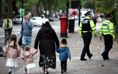 Illustration : Une femme tient des enfants par la main alors que des agents de la police métropolitaine patrouillent dans les rues de Stamford Hill, dans le nord de Londres, le 2 octobre 2025 (HENRY NICHOLLS / AFP) Illustration : Une femme tient des enfants par la main alors que des agents de la police métropolitaine patrouillent dans les rues de Stamford Hill, dans le nord de Londres, le 2 octobre 2025 (HENRY NICHOLLS / AFP)
