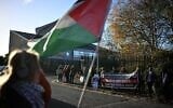 Des partisans de militants du groupe « Palestine Action », accusés d’avoir fait irruption sur le site de la société de défense israélienne Elbit Systems à Bristol en août 2024, brandissant des pancartes et agitant des drapeaux palestiniens devant la Cour d’assises de Woolwich, dans le sud-est de Londres, le 17 novembre 2025, devant laquelle les militants doivent comparaître. (Crédit : Ben Stansall/AFP)