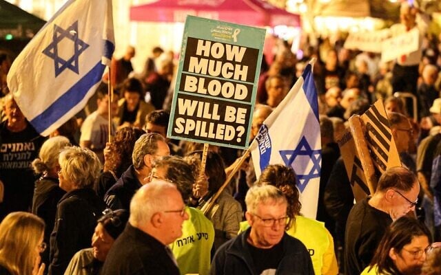 Illustration : Des manifestants brandissant des pancartes contre le gouvernement, sur la Place Habima, à Tel Aviv, le 2 mai 2026. (Crédit : Jack Guez/AFP)