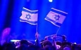 Photo d'illustration : Des supporters israéliens agitant des drapeaux avant la première demi-finale du Concours Eurovision de la chanson 2026, à la Wiener Stadthalle de Vienne, en Autriche, le 12 mai 2026. (Crédit : Tobias Schwarz/AFP)