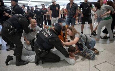 Des agents de la police basque arrêtant des membres de la « Global Sumud Flotilla » à leur arrivée à l'aéroport de Bilbao, le 23 mai 2026. (Crédit : Idurre Etxaburu/AFP)