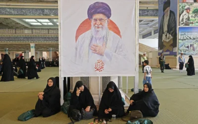 Des Iraniennes sont assises devant une image du guide suprême assassiné Ali Khamenei alors qu’elles se rassemblent à la mosquée de l’imam Khomeini à Téhéran, en Iran, pour une commémoration des morts de la guerre, le 24 mai 2026. (Crédit: ATTA KENARE / AFP)