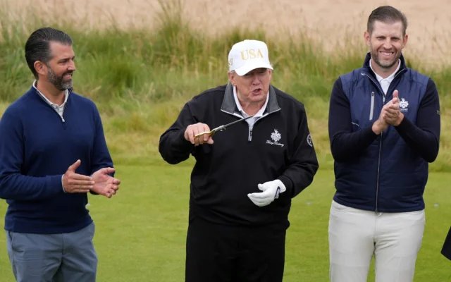 Le président américain Donald Trump, au centre, tient des ciseaux pour couper le ruban, aux côtés de ses fils Donald Trump Jr., à gauche, et Eric Trump, lors de la cérémonie d'inauguration du Trump International Golf Links près d'Aberdeen, en Écosse, le 29 juillet 2025. (Crédit: AP Photo/Alastair Grant)