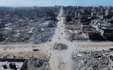 Sur cette photo prise par un drone, on voit des Palestiniens traverser un carrefour entouré de bâtiments détruits par deux années de bombardements israéliens à Gaza City, le mercredi 15 octobre 2025. (Crédit : AP)