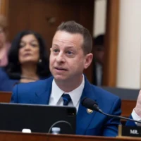 Le député américain Jared Moskowitz, démocrate de Floride, brandit une Bible de Trump alors qu’il interroge la procureure générale Pam Bondi devant la commission judiciaire de la Chambre des représentants au Capitole à Washington, le 11 février 2026. (AP Photo/J. Scott Applewhite)