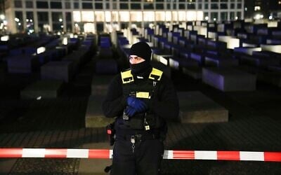 Un policier monte la garde devant le mémorial de l'Holocauste à Berlin, en Allemagne, à la suite d'une agression à l'arme blanche survenue sur place le 21 février 2025. (Crédit : Ebrahim Noroozi/AP)