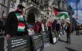 Des partisans de « Palestine Action » manifestant devant la Cour royale de justice à Londres, au Royaume-Uni, le 28 avril 2026. (Crédit : Kin Cheung/AP)