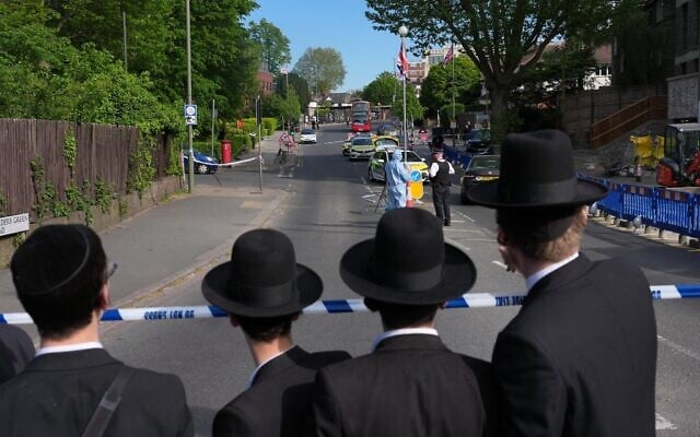 Illustration : Des habitants observant les enquêteurs qui ratissent les lieux après que deux personnes ont été poignardées dans le quartier de Golders Green, qui compte une importante communauté juive, à Londres, le 29 avril 2026. (Crédit : Kin Cheung/AP) Illustration : Des habitants observant les enquêteurs qui ratissent les lieux après que deux personnes ont été poignardées dans le quartier de Golders Green, qui compte une importante communauté juive, à Londres, le 29 avril 2026. (Crédit : Kin Cheung/AP)