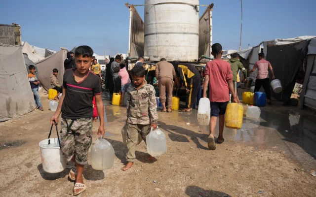 Des Palestiniens déplacés se rassemblent pour aller chercher de l'eau à un camion dans un campement de fortune à Khan Younis, dans le sud de la bande de Gaza, le 30 avril 2026. (Crédit: AP/Abdel Kareem Hana) Des Palestiniens déplacés se rassemblent pour aller chercher de l'eau à un camion dans un campement de fortune à Khan Younis, dans le sud de la bande de Gaza, le 30 avril 2026. (Crédit: AP/Abdel Kareem Hana)