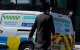 Un homme passant devant un véhicule des services d'enquête et d'intervention, près du lieu où deux Juifs ont été poignardés dans le quartier de Golders Green, à Londres, le 30 avril 2026. (Crédit : Alastair Grant/AP)