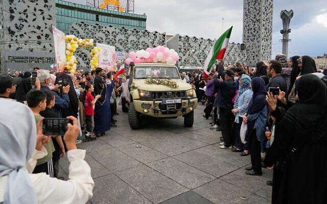 Des jeunes mariés à bord de camionnettes lors d'une cérémonie de mariage collective organisée pour les couples participant à la campagne gouvernementale « Janfada » (« Sacrifice pour l'Iran »), à Téhéran, en Iran, le 18 mai 2026. (Crédit : Vahid Salemi/AP)