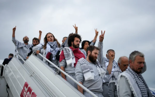 Des activistes de la « Global Sumud Flotilla » descendent d’un avion à leur arrivée à l’aéroport, à Istanbul, en Turquie, le 21 mai 2026. (Crédit : Emrah Gurel/AP)