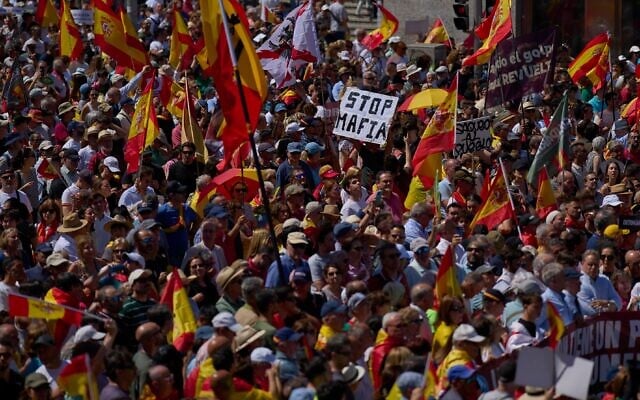 Des manifestants brandissant des drapeaux espagnols participent à une manifestation contre le gouvernement du Premier ministre Pedro Sánchez à Madrid, en Espagne, le samedi 23 mai 2026. (Crédit : AP/Manu Fernandez)