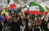Illustration : Des partisans du gouvernement brandissant des drapeaux iraniens et des photos du guide suprême iranien, l'ayatollah Mojtaba Khamenei, lors d'une cérémonie en l'honneur des forces armées et des victimes de la guerre contre Israël et les États-Unis, à la Grande Mosquée de l'imam Khomeini, à Téhéran, en Iran, le 24 mai 2026. (Crédit : Vahid Salemi/AP)