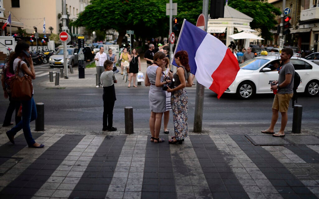 Des personnes brandissent un drapeau français sur le boulevard Rothschild, à Tel Aviv, à l'occasion des célébrations de la Fête nationale française, le 14 juillet 2015. (Crédit : Tomer Neuberg/Flash90)