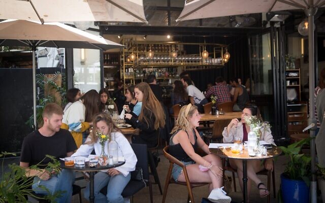 Des Israéliens sont attablés dans un restaurant à Tel Aviv, le 4 avril 2021. (Crédit : Miriam Alster/FLASH90)