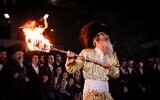 Le rabbin Nachman Biderman et ses disciples allumant un feu de joie lors des célébrations de Lag BaOmer, sur le mont Meron, le 16 mai 2025. (Crédit : David Cohen/Flash90)