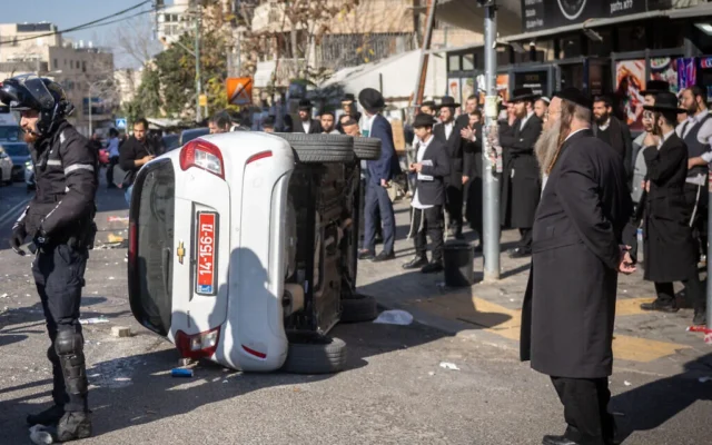 Une voiture de police renversée suite à une émeute en marge d'une manifestation contre l'incarcération d'un étudiant juif de Yeshiva réfractaire au service militaire, à Jérusalem, le 18 décembre 2025. (Chaim Goldberg/Flash90)