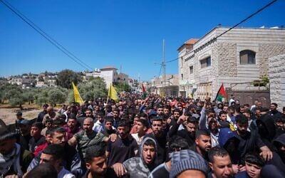 Des Palestiniens assistant aux funérailles d'Aws Hamdi Al-Naasan, 14 ans, et de Jihad Marzouq Abu Naim, 32 ans, qui auraient été tués par des tirs de résidents d'implantations, à al-Mughayyir, à l'est de Ramallah, en Cisjordanie, le 22 avril 2026. (Crédit : Flash90)