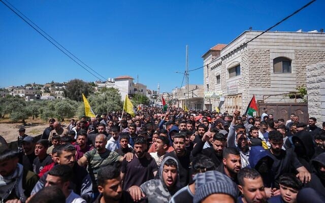 Des Palestiniens assistant aux funérailles d'Aws Hamdi Al-Naasan, 14 ans, et de Jihad Marzouq Abu Naim, 32 ans, qui auraient été tués par des tirs de résidents d'implantations, à al-Mughayyir, à l'est de Ramallah, en Cisjordanie, le 22 avril 2026. (Crédit : Flash90)