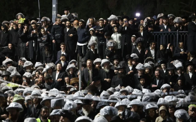 Des gens se rassemblent pour assister à l'allumage du grand feu central lors des célébrations de Lag Ba'omer sur le mont Meron, dans le nord d'Israël, le 4 mai 2026. (Crédit: David Cohen/Flash90)