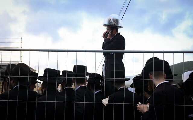Des Juifs ultra-orthodoxes rassemblés derrière une barrière lors des célébrations de Lag BaOmer, sur le mont Meron, dans le nord d'Israël, le 4 mai 2026. (Crédit : David Cohen/Flash90)