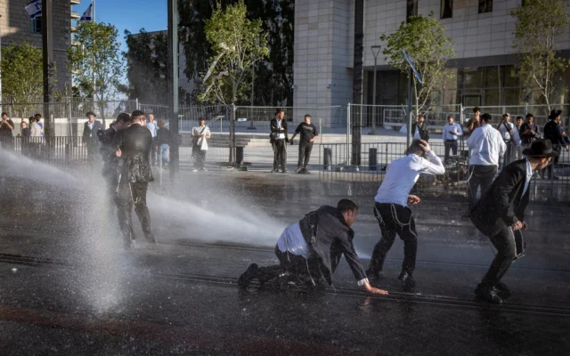 Des hommes juifs ultra-orthodoxes affrontent la police à Jérusalem lors d'une manifestation contre l'incarcération d'étudiants de séminaire qui n'ont pas respecté leurs obligations d'enrôlement militaire, le 7 mai 2026. (Crédit: Chaim Goldberg/Flash90)