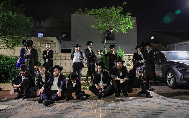 Des Juifs ultra-orthodoxes manifestant contre l’incarcération d’étudiants en yeshiva ayant échappé à la conscription, devant le domicile du chef de la police militaire, le général de brigade Yuval Yamin, à Ashkelon, le 14 mai 2026. (Crédit : Tsafrir Abayov/Flash90)