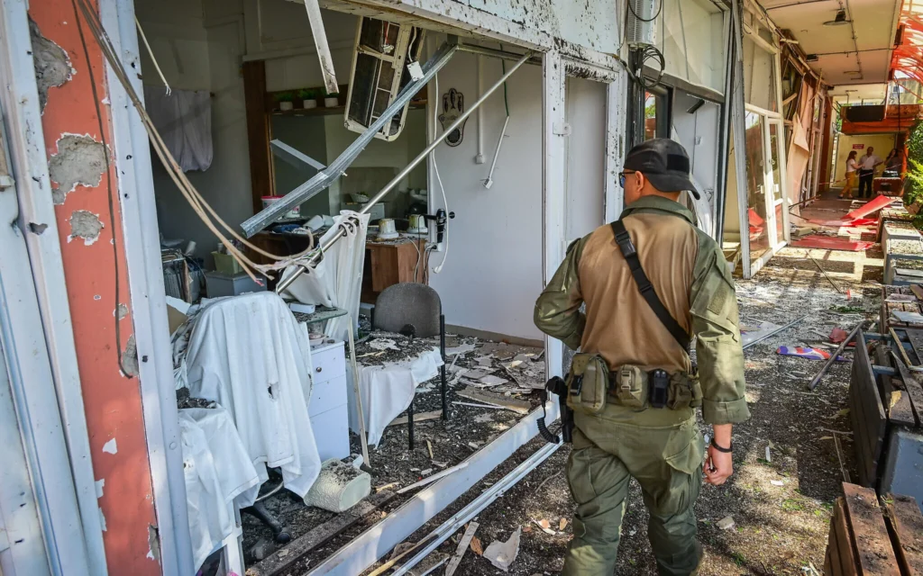 Un membre des forces de sécurité inspectant les lieux où une roquette du groupe terroriste chiite libanais du Hezbollah a frappé la ville de Kiryat Shmona, dans le nord du pays, le 30 mai 2026. (Crédit : Michael Giladi/Flash90)
