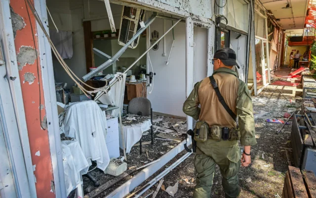 Un membre des forces de sécurité inspectant les lieux où une roquette du groupe terroriste chiite libanais du Hezbollah a frappé la ville de Kiryat Shmona, dans le nord du pays, le 30 mai 2026. (Crédit : Michael Giladi/Flash90)