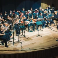 Tom Cohen dirige le programme pour les jeunes du Jerusalem Orchestra East & West à Tel Aviv, en mai 2026. (Yaakov Buta via la JTA)