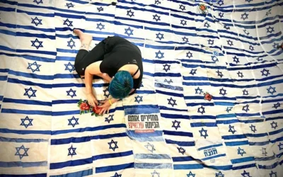L'artiste Tal Tenne Czaczkes travaille sur son œuvre « Flag of Flags », une immense voûte composée de drapeaux israéliens usagés actuellement exposée en Israël, en mai 2026 (Roni Czaczkes)