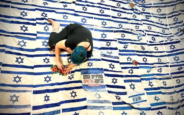 L'artiste Tal Tenne Czaczkes travaille sur son œuvre « Flag of Flags », une immense voûte composée de drapeaux israéliens usagés actuellement exposée en Israël, en mai 2026 (Roni Czaczkes)