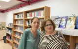Ayala Ben-David (à gauche) et Galia Handelman, des bibliothécaires qui travaillent désormais dans la bibliothèque temporaire de Shlomi depuis la destruction de la bibliothèque par une roquette du Hezbollah en octobre 2024, photographiées le 27 mai 2026. (Diana Bletter/Times of Israel)