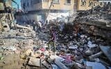 Des Gazaouis sur le site d'une frappe aérienne israélienne, à Deir al-Balah, dans la bande de Gaza, le 24 mai 2026. (Crédit : Khalil Kahlout/Flash90)