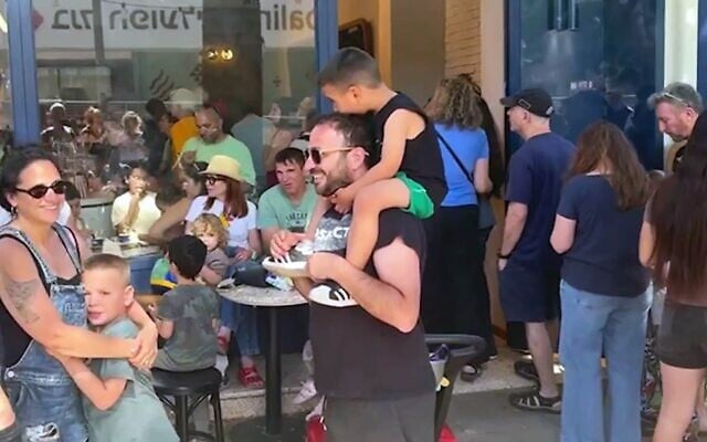 Des personnes faisant la queue devant le glacier Otello pour protester contre l'amende infligée à l'établissement pour avoir ouvert à Shabbat, à Rehovot, le 16 mai 2026. (Crédit : Capture d'écran/Ynet) Des personnes faisant la queue devant le glacier Otello pour protester contre l'amende infligée à l'établissement pour avoir ouvert à Shabbat, à Rehovot, le 16 mai 2026. (Crédit : Capture d'écran/Ynet)