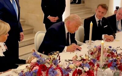 Une capture d'écran d'une vidéo diffusée par la Maison Blanche montre le président américain Donald Trump en train de signer la version en persan du protocole d'accord avec l'Iran, au château de Versailles, en France, le 17 juin 2026. (Crédit : Capture d'écran X)