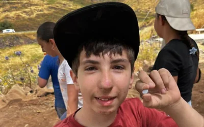 Alon Horowitz, élève de sixième, a découvert une pierre rare de type « Nicolo », datant probablement d'au moins 1 500 ans, lors de fouilles communautaires au parc national de Korazim, une découverte annoncée le 1er juin 2026. (Équipe des fouilles de Korazim / Autorité israélienne de la nature et des parcs)