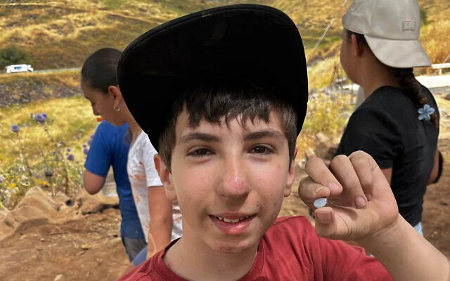 Alon Horowitz, élève de sixième, a découvert une pierre rare de type « Nicolo », datant probablement d'au moins 1 500 ans, lors de fouilles communautaires au parc national de Korazim, une découverte annoncée le 1er juin 2026. (Équipe des fouilles de Korazim / Autorité israélienne de la nature et des parcs)