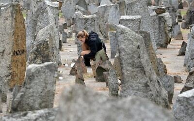 Une scout polonaise allumant une bougie devant le monument du camp d'extermination nazi de Treblinka, datant de la Seconde Guerre mondiale, à Treblinka, le 2 octobre 2013. (Crédit : Janek Skarzynski/AFP)