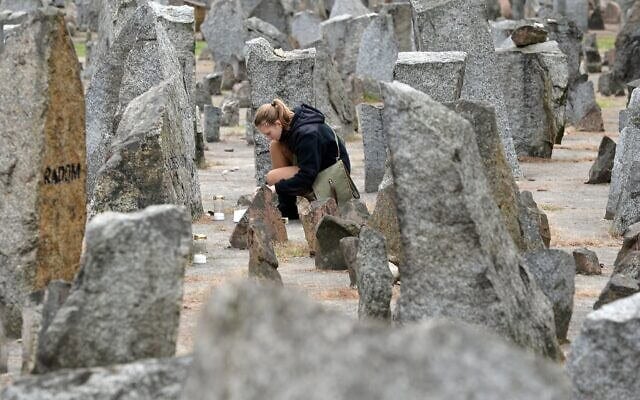 Une scout polonaise allumant une bougie devant le monument du camp d'extermination nazi de Treblinka, datant de la Seconde Guerre mondiale, à Treblinka, le 2 octobre 2013. (Crédit : Janek Skarzynski/AFP)
