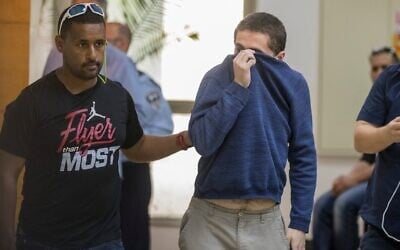 L’Américano-israélien Michael Kadar (à droite), accusé d’avoir proféré des dizaines de menaces antisémites à la bombe aux États-Unis et ailleurs, escorté par des gardes à sa sortie du tribunal de Rishon LeZion, le 23 mars 2017. (Crédit : Jack Guez/AFP) L’Américano-israélien Michael Kadar (à droite), accusé d’avoir proféré des dizaines de menaces antisémites à la bombe aux États-Unis et ailleurs, escorté par des gardes à sa sortie du tribunal de Rishon LeZion, le 23 mars 2017. (Crédit : Jack Guez/AFP)