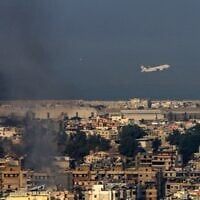 Un avion commercial de Middle East Airlines décollant de l'aéroport international de Beyrouth traversant un nuage de fumée s'élevant au-dessus de la banlieue sud de la capitale libanaise, au lendemain des frappes aériennes israéliennes de la nuit, le 28 septembre 2024. (Crédit : AFP)