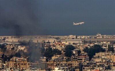 Un avion commercial de Middle East Airlines décollant de l'aéroport international de Beyrouth traversant un nuage de fumée s'élevant au-dessus de la banlieue sud de la capitale libanaise, au lendemain des frappes aériennes israéliennes de la nuit, le 28 septembre 2024. (Crédit : AFP)